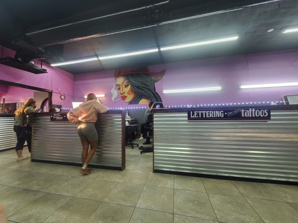 A clean and organized tattoo studio interior, with various tattoo designs displayed on the walls.